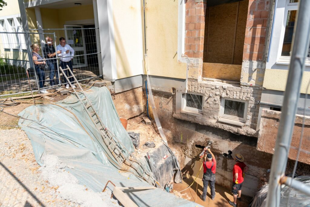 Bürgermeister Thorsten Feike (v.r.), Schulleiter Manfred Görth und Stadt-Mitarbeiterin Sina Stelter-Bode machen sich ein Bild vom Baufortschritt.