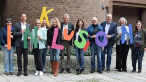 Das Foto zeigt eine Gruppe von Menschen, die das Wort "Inklusion" in einzelnen großen Buchstaben hochhalten.